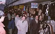 The Mayor of Seoul Yeom Bo-hyeon&nbsp;[ko] (front, black tie) tours the market (1983)