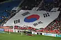a large display of the South Korean flag during an association football match against Haiti