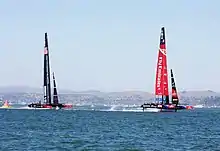 Color photograph of a racing catamaran underway with the starboard hull out of the water