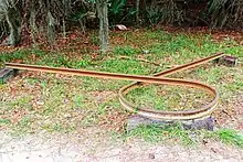 Rusted railroad rail bent in a circle, known as a Sherman's necktie