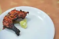 A portion of a tandoori chicken, at a restaurant in India.