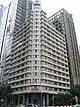 Beige rectangular building, 20 storeys and at 87 metres tall, with newer taller skyscrapers seen in the background.