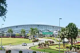 Roadside exterior view of passenger terminal at Brunei International Airport, with approach roads in foreground.