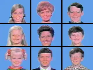 A 3 × 3 grid of squares with face shots of all nine starring characters of the television series: three blond girls in the left three squares, three brown-haired boys in the right three squares, and the middle three squares feature a blond, motherly woman, a dark-haired woman, and a brown-haired man; all the faces are on blue backgrounds.