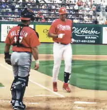 A man in a Philadelphia Phillies' uniform walking from third base to home plate