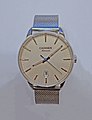 A watch with a fine stainless steel Milanese (dense and tight braided mesh variant) bracelet.