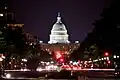 The U.S. Capitol Building lit up at night with the streets of Washington D.C.