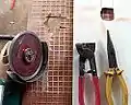 100&nbsp;mm (4") angle grinder with diamond blade, with tiling snips being used to cut holes in tiles