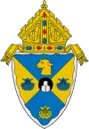 The arms of the Diocese of Rockville Centre: The mounds in the circle at the center of the arms are a play on the name of city in which the diocese is based, Rockville Centre, New York.