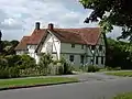 39 The Causeway is a late 14th-century timber-framed house, extended in the 15th and 17th centuries. It is Grade II* listed. A cruck frame and an external bread oven are visible in the gable wall nearest the camera.