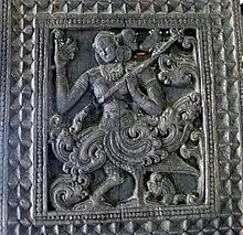 stick zither veena in the hands of a Kinnari