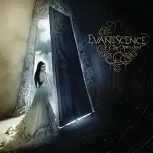 A woman in a dress standing in the entryway of a building, without light shining upon her. In the top right corner of the image, the words "Evanescence" and "The Open Door" are placed.