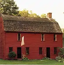Simple, two-story wooden house. The two doors open directly on to the front lawn.