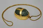 Heart scarab of Hatnefer; 1492–1473&nbsp;BC; serpentine (the scarab) and gold; 5.3 × 2.8&nbsp;cm; chain: 77.5&nbsp;cm; Metropolitan Museum of Art