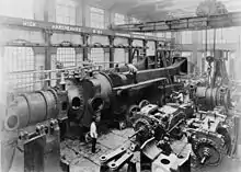 Under assembly c.1890, half of one of the two 10,000 hp engines completed for Deptford Power Station at Hick, Hargreaves and Co. A travelling crane and hoist above.