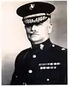 an image of a white male in his military uniform with a hat on and a mustache. Military style ribbons are clearly visible.
