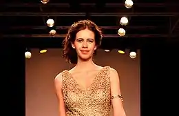  Koechlin walking the ramp in gold dress.