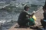 After emerging from the sea, haenyeo selling her gathered seafood to people on the coast of Jeju.