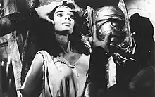 A woman about to have a bronze masked placed on her face