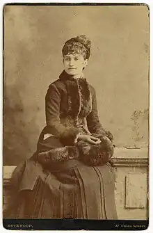 Mary Harrison McKee sitting while wearing a dress