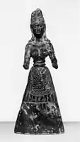 Baltimore stone figure, probably a fake, pre-1929. A snake winds round the headdress and the hands are pierced as if to hold snakes.