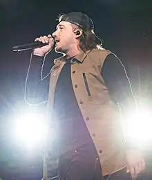 Wallen holding a microphone on stage.