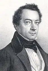 Photograph of a lithograph. It shows the head and shoulders of a middle-aged man  dressed formally, and is wearing a coat, a white shirt with a high collar, and a bow tie.