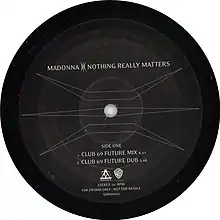 Side one of a black record with a symbol covering the surface and letters mentioning the two versions of the song