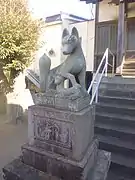 Detail view of the left fox guardian of the shrine Aratama Inari Jinja in Numazu with kit
