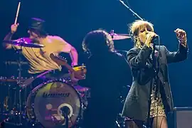 Parmore performing in 2023. Left to right: Zac Farro (drummer), Taylor York (lead guitarist), and Hayley Williams (lead vocalist)