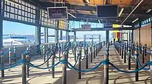 A picture of the interior of the Pier 50 passenger ferry terminal. This image shows the lines set up in front of the ramp that leads onto the ferries, and the Doc Maynard visible through the windows.