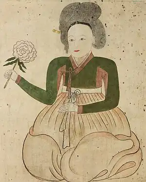 Lady on white background holding flower.