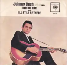 A man holds a guitar; the neck reads "Johnny Cash".