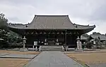 Wooden building with a hip-and-gable roof.