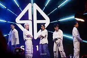 A group portrait of SB19 with each member wearing casual streetwear combining white tops with white or denim pants.