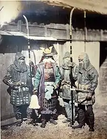 1870 photograph of samurai and retainers wearing mail armour and holding naginata
