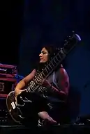 A woman sitting while playing a sitar