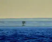 In this mirage, at least three separate images of a boat are visible. The real one at the bottom and the uppermost one are in the upright position, whereas the one in the middle is inverted.