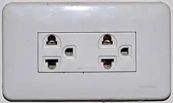 An earthed Thai socket that appears to comply with figure&nbsp;4 of TIS&nbsp;166-2549. Although it may accept NEMA plugs, the Thai voltage is 220&nbsp;V and thus is electrically incompatible with devices designed only for 110&nbsp;V.