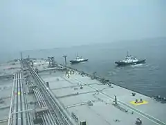 Tugs towing an oil tanker (VLCC)