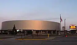 A brightly lit hockey arena, clad in metal panels.