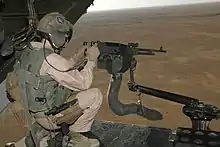 M240 machine gun mounted on V-22 loading ramp with a view of Iraq landscape with the aircraft in flight