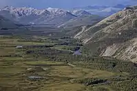 Aerial view of a mountainous landscape above small lakes and a winding river