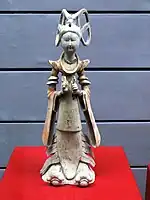 Fashionably-dressed female attendant of the early, slender, type